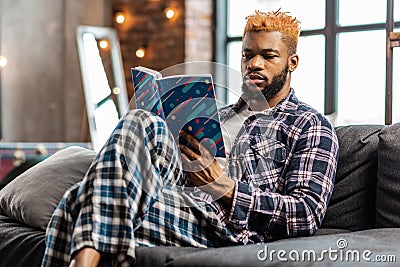 Smart nice man resting at home with a book Stock Photo