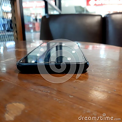 Smart phone black above brown table Stock Photo