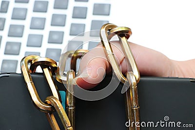 A smart phone is tied to a man`s hand by a sturdy chain. Stock Photo