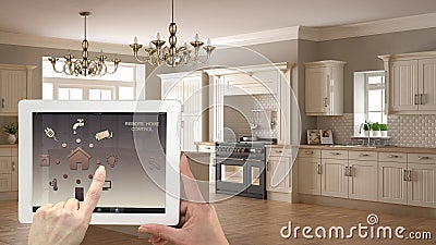 Smart remote home control system on a digital tablet. Device with app icons. Interior of classic white and wooden kitchen in the b Stock Photo