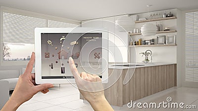 Smart remote home control system on a digital tablet. Device with app icons. Modern kitchen with shelves and cabinets in the Stock Photo