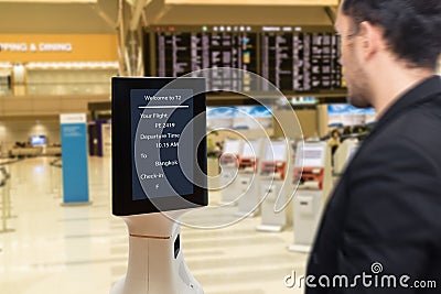 Smart robotic technology concept, The passenger follow a service robot to a counter check in in airport, the robot can help and gi Stock Photo