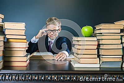 Smart school boy reading a book at library Stock Photo