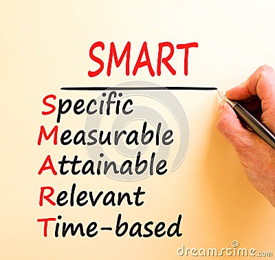 SMART symbol. Concept words SMART specific measurable attainable relevant time-based on paper. Beautiful brown background. Stock Photo