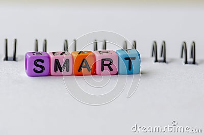 SMART text on colorful plastic beads representing Specific, Measurable, Achievable, Relevant and Time Bound with notepad Stock Photo