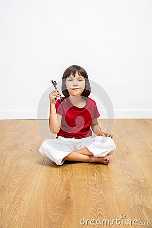 Smart thinking little girl holding key for concept of solution Stock Photo