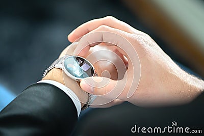 Smart watch with touch screen. Business man using wearable device with mobile technology. Smartwatch with finance report. Stock Photo
