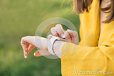 Smart watch on woman& x27;s hand outdoor. Girl using smartwatches. Young woman browsing notificatins on modern smart Stock Photo