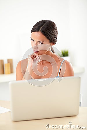 Smart woman thinking while working on computer Stock Photo