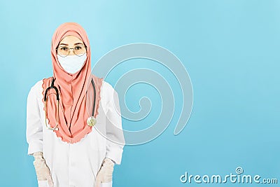 Smart young asian muslim woman doctor in lab coat with Medical face mask,white latex medical gloves and stethoscope against blue Stock Photo