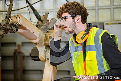 smart young engineer work service maintenace programming automatic robot welding machine in heavy metal automation factory Stock Photo