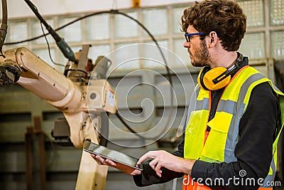 smart young engineer work service maintenace programming automatic robot welding machine in heavy metal automation factory Stock Photo