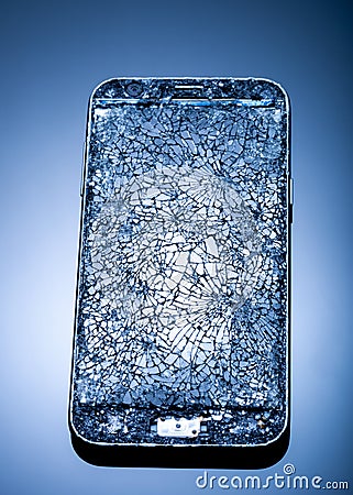 Smarthphone with crushed screen into pieces on a blue reflective surface, studio shot / Destroied equipment Stock Photo