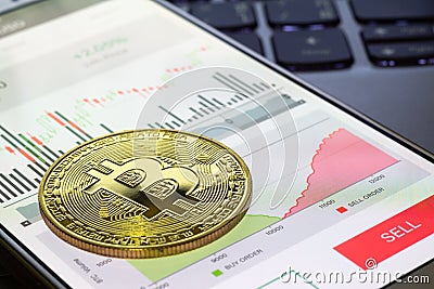 Smartphone with Bitcoin Trading via appliaction with golden bitcoin on the mobile phone. Bitcoins stock trading abstract Stock Photo