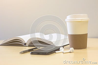 Smartphone with Book turning pages and a cup of coffee Stock Photo