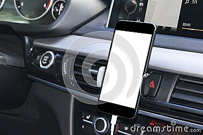 Smartphone in a car use for Navigate or GPS. Driving a car with Smartphone in holder. Mobile phone with white screen. Stock Photo