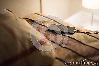 Smartphone is charging on bed Stock Photo