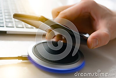 Smartphone charging on a wireless charger Stock Photo