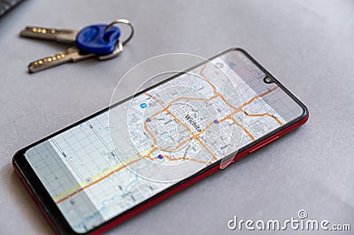 Smartphone and door keys lie against gray. Map of city of Wichita on screen of device. Wichita is city in USA, largest city in Editorial Stock Photo