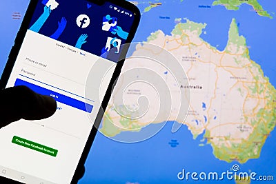 Smartphone with Facebook`s login screen against the map of Australia in the background. Facebook recently blocked users in Austral Editorial Stock Photo