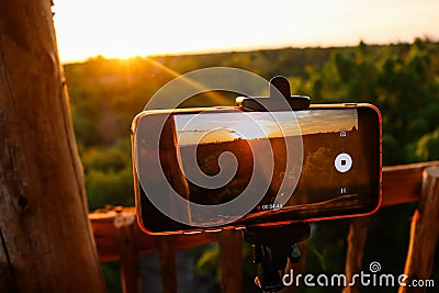 Smartphone filming a forest under the sunlight during the sunset in the evening Stock Photo