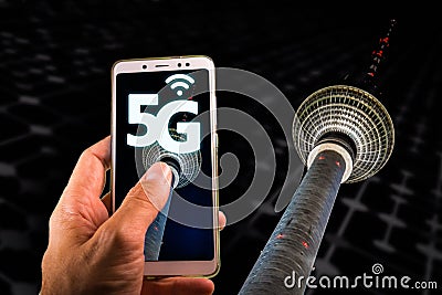 Smartphone with 5G on screen and Famous Berlin television tower or Fernsehturm on the background Stock Photo