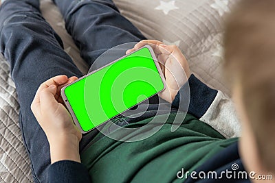 Smartphone with a green screen in hand child . Smartphone with a hromakey in the hands of a child Stock Photo