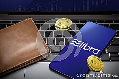 Smartphone with Libra logo on the screen and Libra Cryptocurrency digital golden coins with wallet on notebook, Libra blockchain Editorial Stock Photo