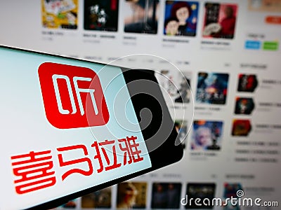 Smartphone with logo of Chinese online radio platform Ximalaya on screen in front of business website. Editorial Stock Photo