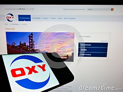 Smartphone with logo of US company Occidental Petroleum Corp (OXY) on screen in front of business website. Editorial Stock Photo