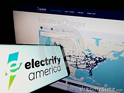 Smartphone with logo of US EV charging company Electrify America LLC on screen in front of business website. Editorial Stock Photo