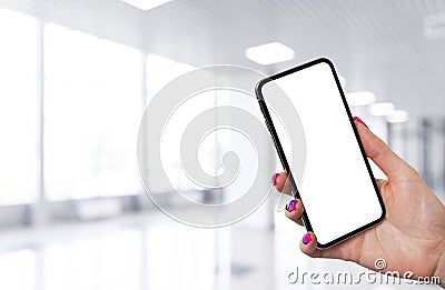 Smartphone mockup in woman hand with business centre background. Modern frameless smartphone mock up with blank white screen. Empt Stock Photo