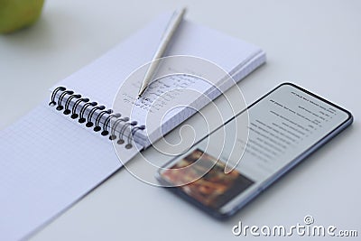 Smartphone with recipe and notebook with notes Stock Photo