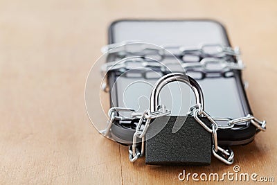 Smartphone tied chain with lock on wooden table, gadget and digital devices detox concept Stock Photo