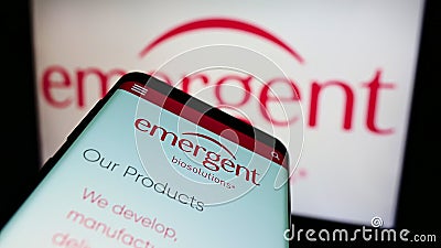 Smartphone with website of American company Emergent BioSolutions Inc. on screen in front of business logo. Editorial Stock Photo