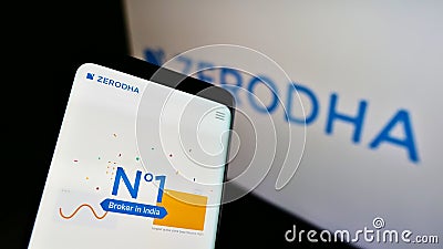 Smartphone with website of Indian financial services company Zerodha Broking Ltd. on screen in front of logo. Editorial Stock Photo