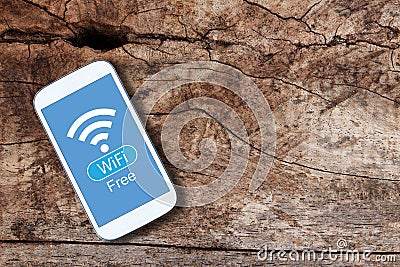 Smartphone with WiFi Free on blue screen on old wooden table Stock Photo