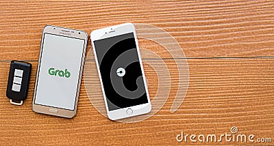 2 smartphones showing UBER and GRAB application Editorial Stock Photo