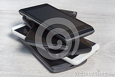 Smartphones stacked on top of each other are on the counter. Stock Photo