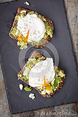 Smashed Avocado and Feta Toast with Poached Eggs Stock Photo