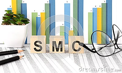 SMC word written on the wood block with chart, glasses and pencils Stock Photo