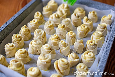 Smearing the dough with egg yolk with silicone brush. Baking in the shape of a rose or snail. Baking snail. Close-up Stock Photo