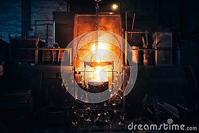 Smelting metal in a metallurgical plant. Liquid iron from metal ladle pouring in castings at factory Stock Photo