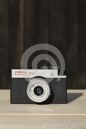 Smena 8M old vintage filtered camera on wooden background Editorial Stock Photo