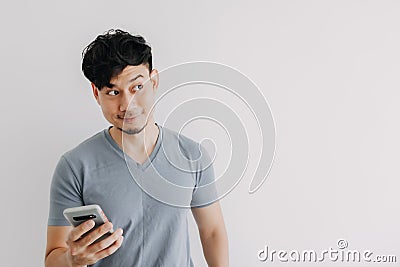 Smile man is happy with the smartphone application isolated on white wall. Stock Photo