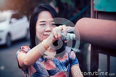 Smile asian woman picked up the newspaper in the morning every day Stock Photo