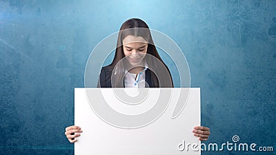 Smile Business woman portrait with blank white board on blue isolated . Female model with long hair. Stock Photo