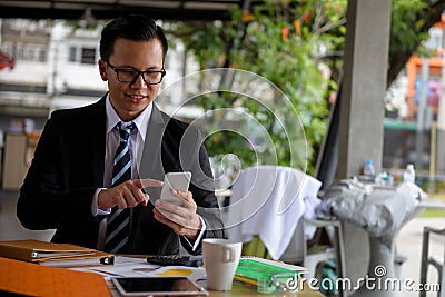 Smile businessman with smartphone in coffee shop Stock Photo