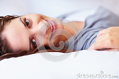 Smile, happy and portrait of woman on bed for rest, daydreaming and comfortable at home. Blanket, relax and face of Stock Photo