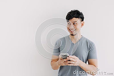 Smile man is happy with the smartphone application isolated on white wall. Stock Photo